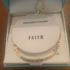 Adjustable bracelet with miniature cross embedded in the adjustable ring.